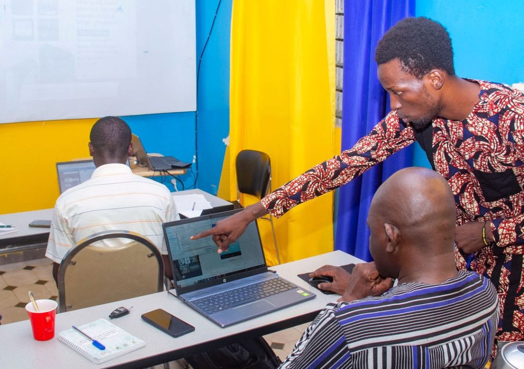 Un formateur accompagne les apprenants en salle